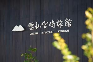 a sign on a building with asian writing on it at Unzen Miyazaki Ryokan in Unzen