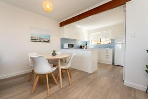 a kitchen and dining room with a table and chairs at South Seas 5- Absolute Beachfront Wifi Views in Port Elliot