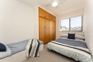 a bedroom with two beds and a window at South Seas 5- Absolute Beachfront Wifi Views in Port Elliot