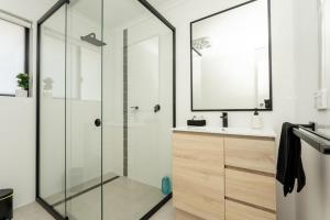 La salle de bains est pourvue d'une douche en verre et d'un lavabo. dans l'établissement South Seas 5- Absolute Beachfront Wifi Views, à Port Elliot