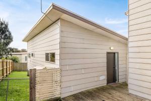 a house with white siding and a door at Bayview Unit in Surf Beach