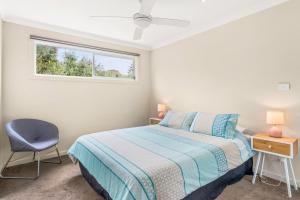 a bedroom with a bed and a window and a chair at Bayview Unit in Surf Beach