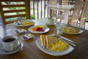 un tavolo con piatti per la colazione e una tazza di caffè di Maharga Bungalows a Nusa Penida