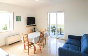 een woonkamer met een tafel en een blauwe bank bij Nice Apartment In Mandre With House Sea View in Mandre