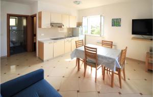 een keuken en eetkamer met een tafel en stoelen bij Nice Apartment In Mandre With House Sea View in Mandre