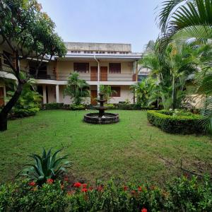 a garden in front of a building with a fountain at Hotel Austria in León