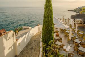 a patio with tables and chairs next to the water at Toboso Apar - Turis in Nerja