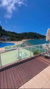 a balcony with a view of a beach and the water at Angra dos reis, Praia Grande cond-angra inn in Angra dos Reis