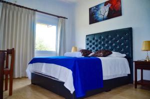 a bedroom with a blue bed with a blue headboard at Hotel Tuunteytas in Villamontes