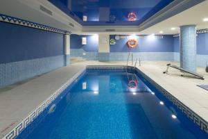 a pool in a hotel room with a swimming pool at Toboso Apar - Turis in Nerja