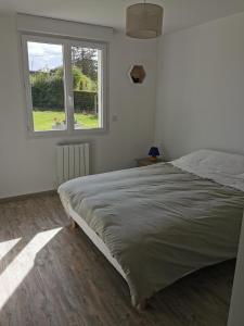 een slaapkamer met een groot bed en een raam bij , Le Noyer Gourmand Havre de paix 5 chambres 2 lits parapluies in Illois