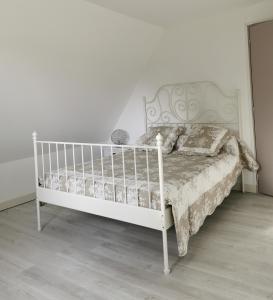 een wit bed in een slaapkamer met een witte muur bij , Le Noyer Gourmand Havre de paix 5 chambres 2 lits parapluies in Illois