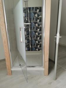 een glazen douche in de badkamer met een glazen deur bij , Le Noyer Gourmand Havre de paix 5 chambres 2 lits parapluies in Illois
