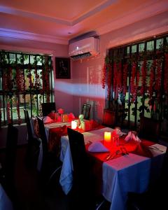 a dining room with tables and chairs with red table cloth at Posh Hotel and Suites Ikeja in Ikeja