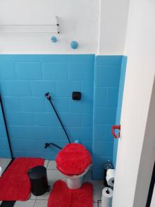 a lego bathroom with a red toilet and blue tiles at Sala living na Av da Praia. in Santos