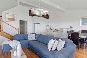 un sofá azul en una sala de estar con cocina en Whitecrest Eco Apartments Great Ocean Road, en Apollo Bay