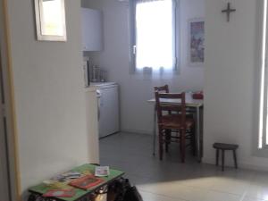 a kitchen with a table and a small kitchen with a cross on the wall at Studio Arcachon, 1 pièce, 2 personnes - FR-1-319-42 in Arcachon