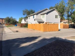 a house on a street with a wooden fence at Cozy Studio in Grand Junction