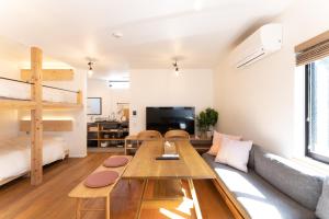 uma sala de estar com uma mesa e um sofá em 強羅base B棟 - GORA base B em Gora