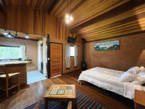 a bedroom with a bed and a desk in a room at Chalés Das Estrelas in Visconde De Maua