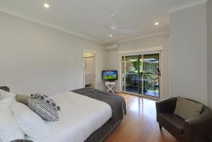 a bedroom with a bed and a chair and a television at The Acreage Boutique Guesthouse in North Avoca