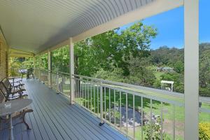 um alpendre com uma mesa e cadeiras em The Acreage Boutique Guesthouse em North Avoca