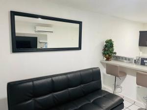 a black leather couch in a room with a mirror at Costa Relax 2 in Guayama