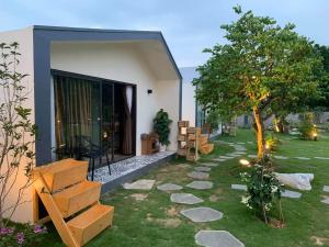 un giardino con una casa con un albero e un sentiero di Hannah Villa Ba Vi - Venuestay a Ba Vì