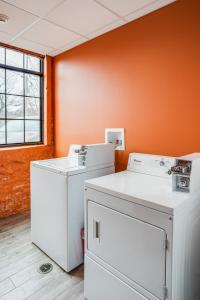 een wasruimte met 2 wastafels en een oranje muur bij NY Style Centric Loft with King Bed by Park ave in Rochester