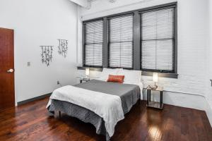 a bedroom with a large bed and two windows at NY Style Centric Loft with King Bed by Park ave in Rochester
