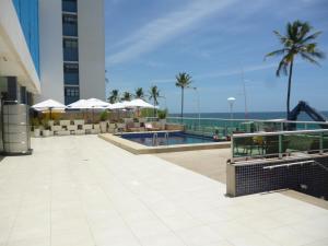 a resort with a swimming pool and the ocean at Bahia Flat 117 in Salvador