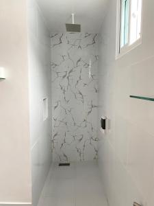 a white bathroom with a cracked wall at HARMAN SUITES Moalboal in Moalboal