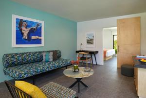 Twin Palms Resort - A Gay Men's Resort في بالم سبرينغز: غرفة معيشة مع أريكة وطاولة