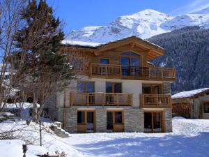 a large house in the snow with snow covered mountains at Appartement Lanslebourg-Mont-Cenis, 4 pièces, 8 personnes - FR-1-508-38 in Lanslebourg-Mont-Cenis