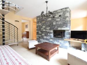 - un salon avec une cheminée en pierre dans l'établissement Appartement Lanslebourg-Mont-Cenis, 4 pièces, 10 personnes - FR-1-508-43, à Lanslebourg-Mont-Cenis