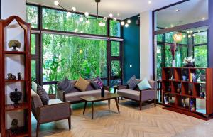 a living room with chairs and a large window at Indra Hotel in Phnom Penh