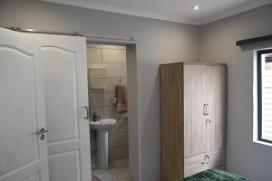 a white bathroom with a sink and a toilet at Montaña Casita - A comfortable and central cottage in Pretoria