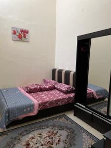 a bedroom with a bed and a mirror at Azlina Homestay Jerantut in Jerantut