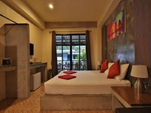 a bedroom with a large white bed with red pillows at The Morning mini house aonang in Ao Nang Beach