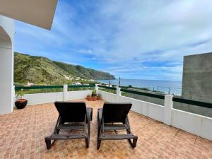 two chairs sitting on a balcony overlooking the ocean at Casa de Praia in Almagreira