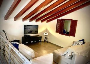 a living room with a couch and a tv at Casa de Praia in Almagreira