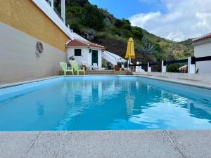 a swimming pool with blue water in front of a house at Casa de Praia in Almagreira