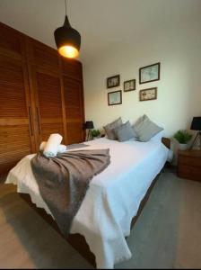 a bedroom with a white bed with a blanket on it at Casa de Praia in Almagreira