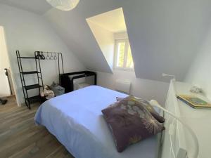 um quarto com uma cama com uma almofada em Maison Bénodet, 4 pièces, 8 personnes - FR-1-481-126 em Bénodet