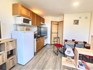 una cucina con frigorifero bianco e armadietti in legno di Studio rénové au centre, près ESF - FR-1-267-243 a Villarembert