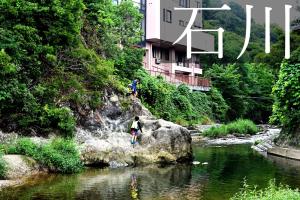 dos personas saltando de rocas en un río en Kawachi no Yado - Vacation STAY 41785v, en Kawachinagano