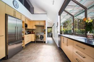 una cucina con armadietti in legno ed elettrodomestici in acciaio inossidabile di Grey Gables - Pet Friendly with Fireplace, Pool, Spa & Sauna a Callala Bay