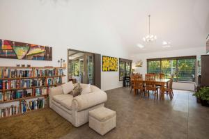 a living room with a couch and a dining room at Grey Gables Pet Friendly with Swimming Pool and Spa in Callala Bay