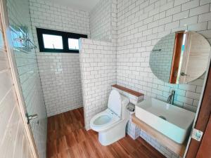 a bathroom with a toilet and a sink and a tub at เดอนาปัว วิลล่า in Ban Chalaeng