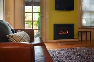 a living room with a couch and a fireplace at Circa Ruby Mint Daylesford in Daylesford +3 photos
